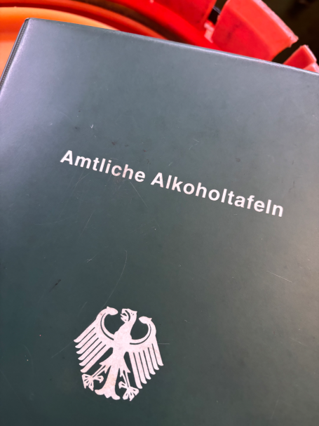 Amtliche Alkoholtafel auf grünem Hintergrund mit Bundesadler-Emblem.