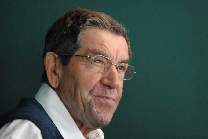 Porträt von Seniorchef Karl Maier (1938-2023) mit freundlichem Ausdruck vor grünem Hintergrund.
